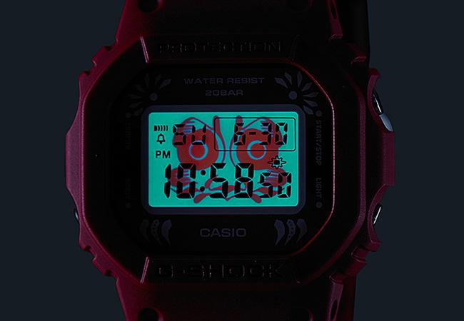 G-SHOCK達摩系列DW-5600DA-4冷光照明，可以看到背景有達摩的造型，並睜著大大的雙眼。